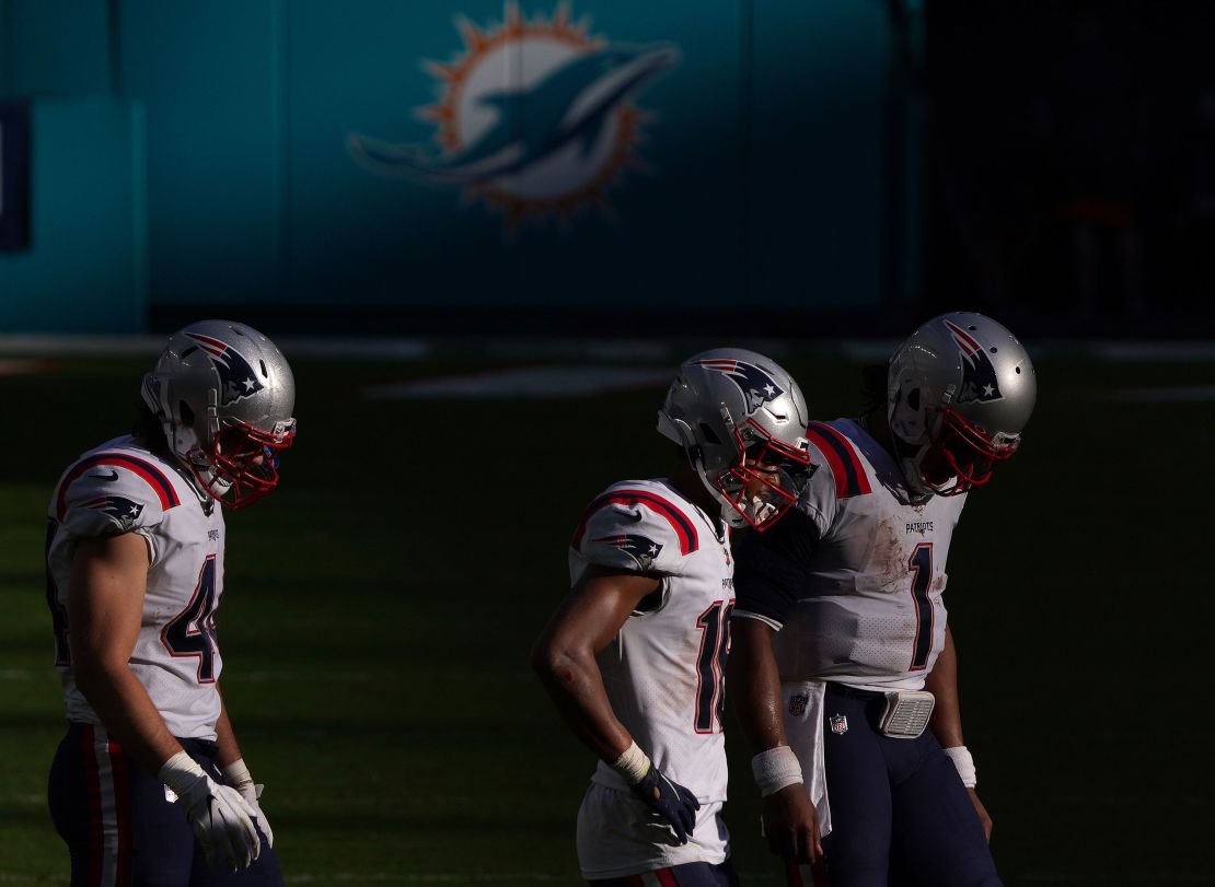Newton (right) walks off the field against the Miami Dolphins. 
