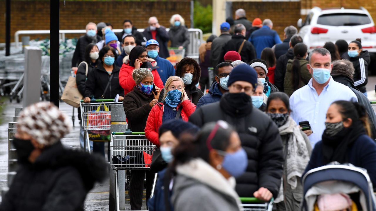 People queue outside a Waitrose supermarket in Harrow, London, as new Tier 4 Covid-19 restrictions threaten shop supplies.