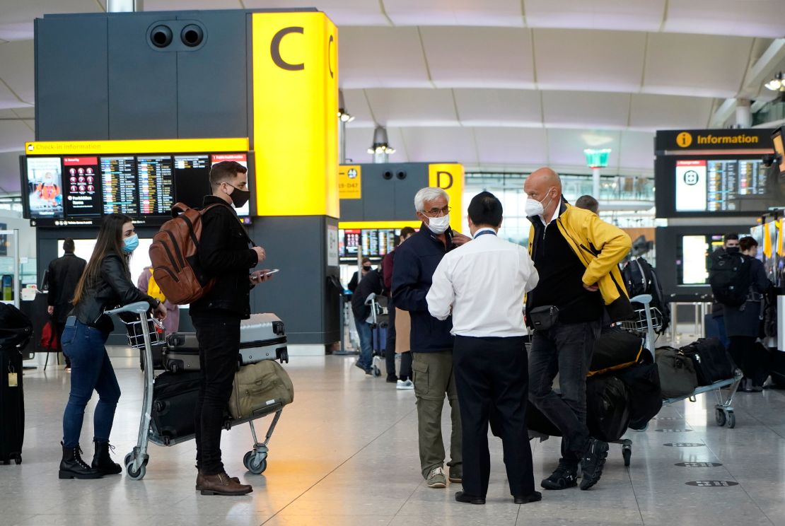 Travelers wearing a face mask or covering stand at check-in desks at Terminal 2 of Heathrow Airport in  London on December 21 as a string of countries around the world banned travellers arriving from the UK.