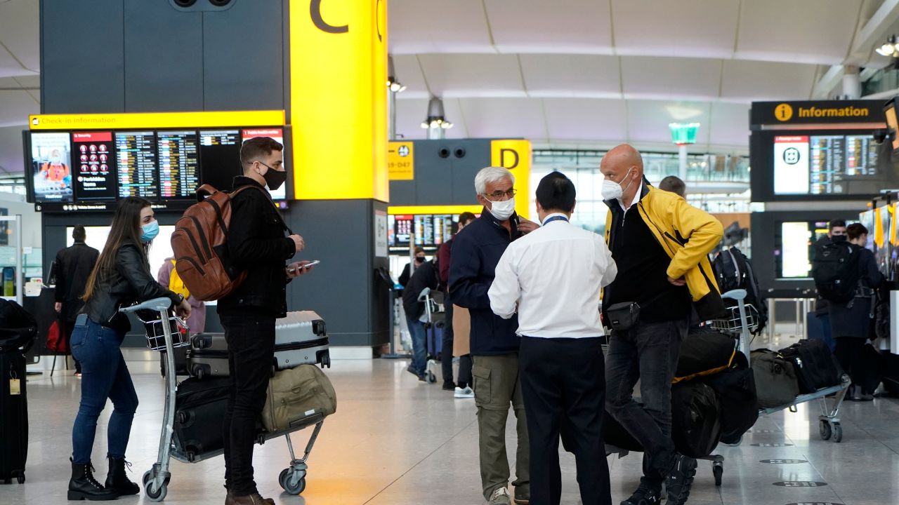 Travellers wearing a face mask or covering due to the COVID-19 pandemic, stand at check-in desks at Terminal 2 of Heathrow Airport in west London on December 21, 2020, as a string of countries around the world banned travellers arriving from the UK, due to the rapid spread of a new, more-infectious coronavirus strain. - Prime Minister Boris Johnson was to chair a crisis meeting Monday as a growing number of countries blocked flights from Britain over a new highly infectious coronavirus strain the UK said was "out of control". (Photo by Niklas HALLE'N / AFP) (Photo by NIKLAS HALLE'N/AFP via Getty Images)