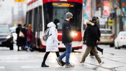 TORONTO, Dec. 19, 2020 -- People wearing face masks cross a street in Toronto, Canada, on Dec. 19, 2020. As of Saturday afternoon, Canada's COVID-19 cases surpassed 500,000, reaching 500,242, with 14,128 deaths, while the vaccine rollout is under way in the country, according to CTV. (Photo by Zou Zheng/Xinhua via Getty) (Xinhua/Zou Zheng via Getty Images)