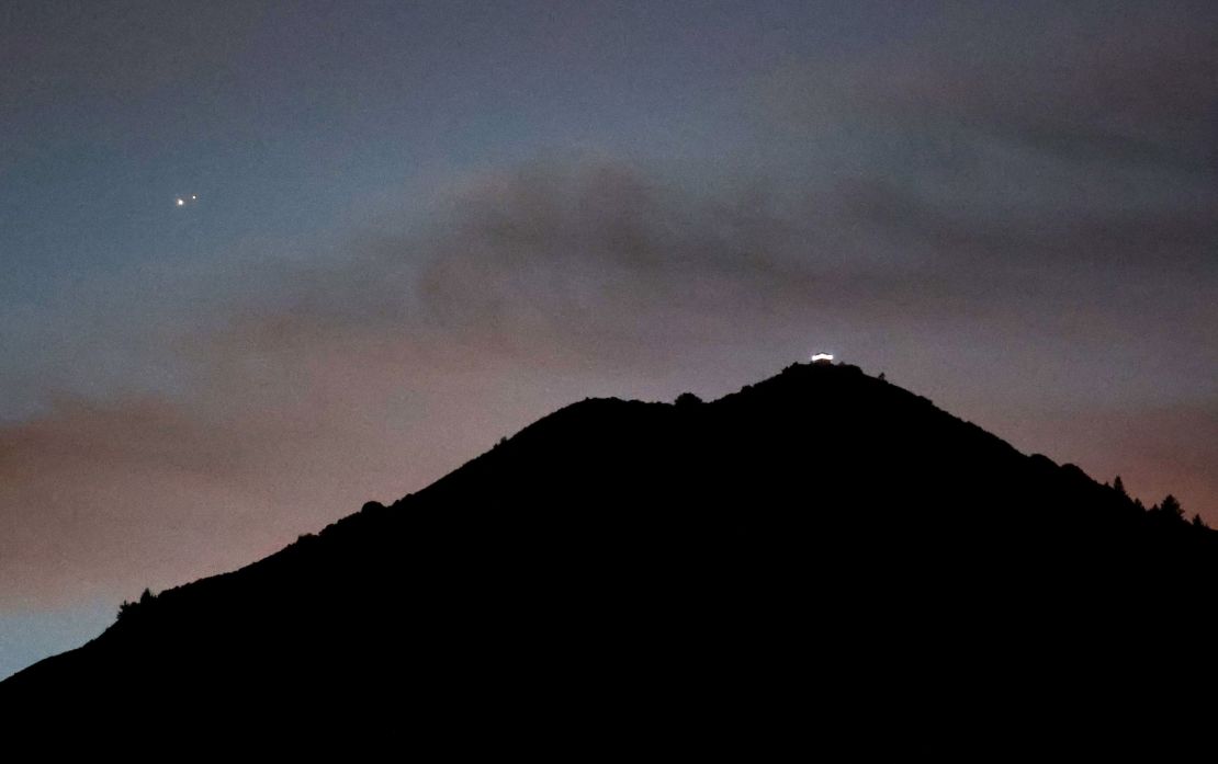 Jupiter, left, and Saturn appear about one-tenth of a degree apart above Mount Tamalpais on Monday in Larkspur, California. 