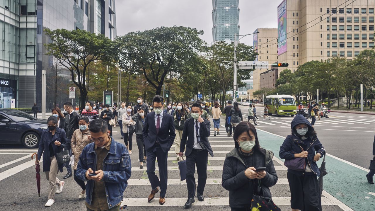 TAIPEI, TAIWAN - DECEMBER 02: Pedestrians wearing face masks cross a street on December 02, 2020 in Taipei, Taiwan. Taiwan imposed mandatory mask-wearing regulations in some circumstances, including on transport services and in markets and restaurants, as it tries to keep its record of controlling Covid-19 infections in check. (Photo by An Rong Xu/Getty Images)