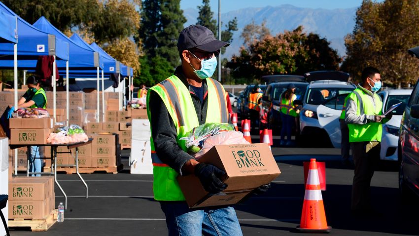 Food is loaded as drivers in their vehicles wait in line on arrival at a "Let's Feed LA County" food distribution hosted by the Los Angeles Food Bank on December 4, 2020 in Hacienda Heights, California. - While coronavirus cases continue to surge nationwide and shutdowns return, the US economic recovery stalls with just 245,000 jobs in the final report of 2020 as the unemployment rate fell to 6.7 percent, according to Bureau of Labour Statistics. (Photo by Frederic J. BROWN / AFP) (Photo by FREDERIC J. BROWN/AFP via Getty Images)