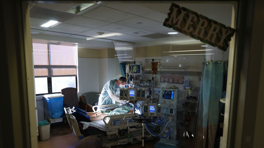 CHULA VISTA, CALIFORNIA - DECEMBER 21: Respiratory therapist Andrew Hoyt cares for a COVID-19 patient in the Intensive Care Unit (ICU) at Sharp Chula Vista Medical Center, with the word 'Merry' posted on the window a few days before Christmas, on December 21, 2020 in Chula Vista, California. According to state figures, Southern California currently has 0 percent of its ICU (Intensive Care Unit) bed capacity remaining amid a spike in COVID-19 cases and hospitalizations. (Photo by Mario Tama/Getty Images)