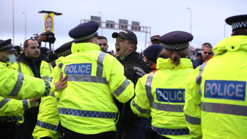 DOVER, ENGLAND - DECEMBER 23: A man shouts at police officers at the Port of Dover on December 23, 2020 in Dover, United Kingdom. Nearly 3,000 lorries were stranded around Kent after France banned all travel from the UK on Sunday, citing concerns over a new variant of covid-19. Late Tuesday, the countries reached a deal to restart freight travel for drivers with a recent negative covid-19 test. (Photo by Dan Kitwood/Getty Images)