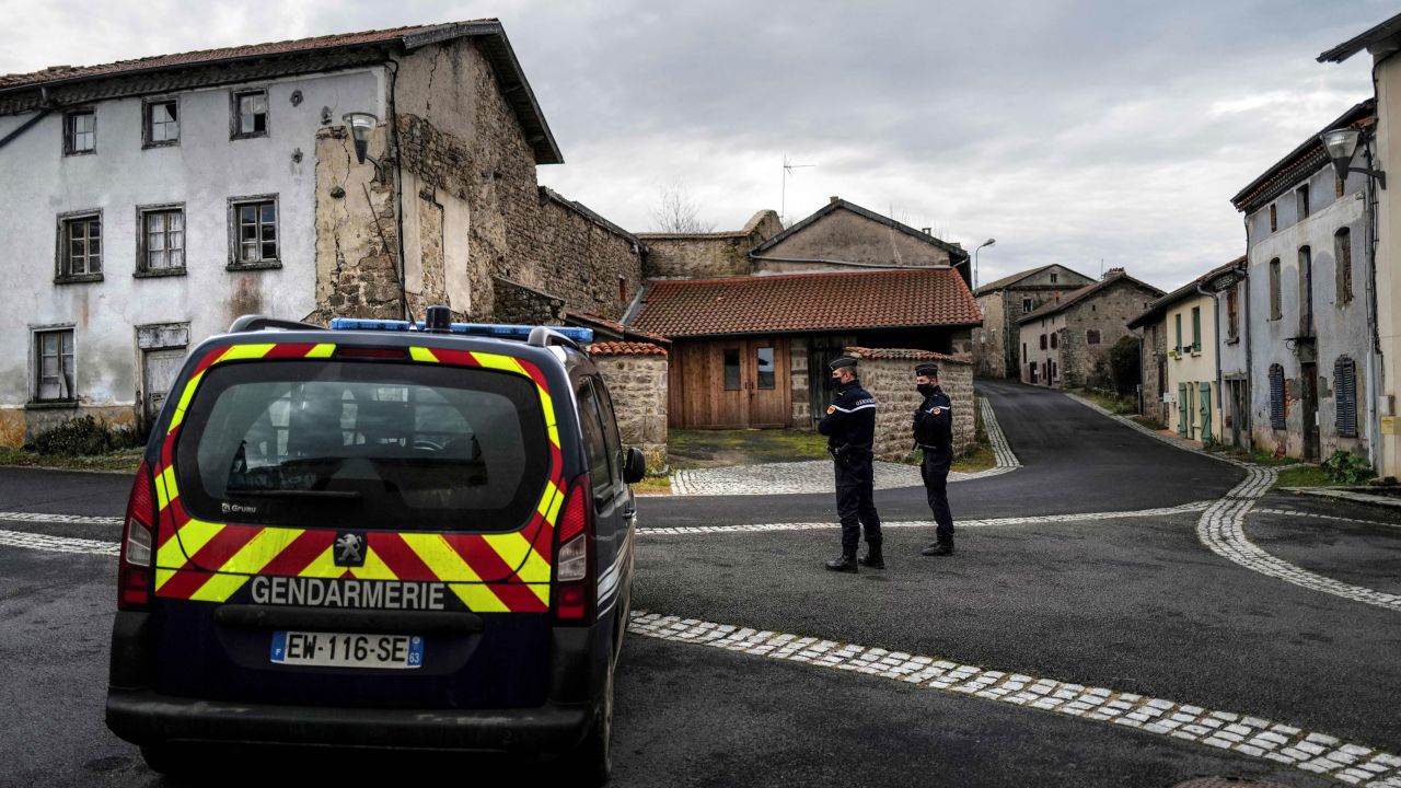 French gendarmes stand guard in a street in Saint-Just, central France on December 23, 2020, after three gendarmes were killed and a fourth wounded by a gunman they confronted in response to a domestic violence call.