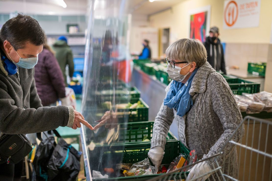 People receive fruit and vegetables from volunteers at a Tafel food bank in Schweinfurt, Germany in November.