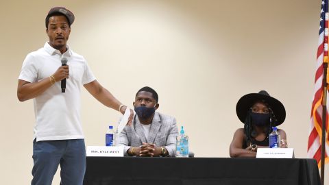 T.I. speaks at a Las Vegas summit on race and policing in June, as activist Kyle West and comedian Lady A.K. McMorris look on.