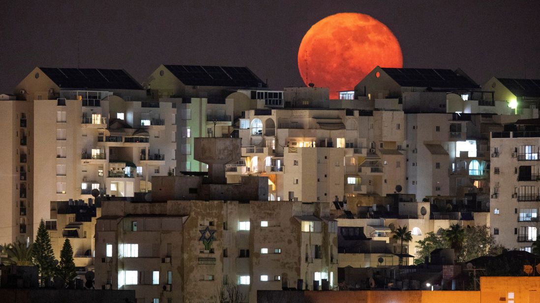 <strong>Ashkelon, Israel: </strong>At night, a full moon peeks out behind residential buildings in the coastal Israeli city of Ashkelon. 