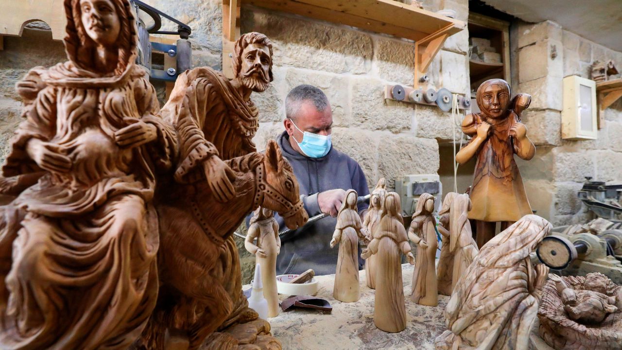<strong>Bethlehem, West Bank:</strong> A carpenter near the Church of the Nativity carves out a series of religious statues and figurines from olive wood on December 21. 