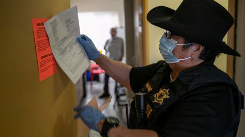 Maricopa County constable Darlene Martinez posts an eviction order for non-payment of rent on October 1 in Phoenix, Arizona. (Photo by John Moore/Getty Images)
