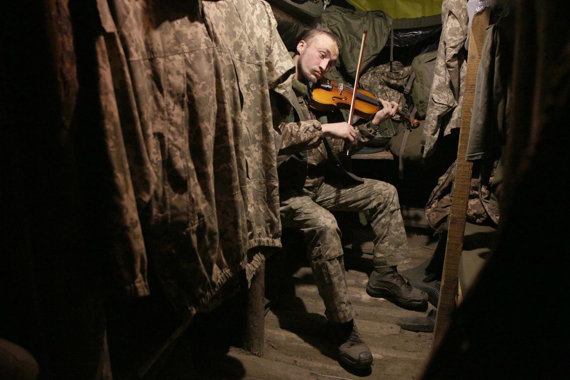 A Ukrainian soldier plays the violin in a dugout on the front lines against Russia-backed separatists in the Donetsk region of eastern Ukraine on Tuesday, December 22.