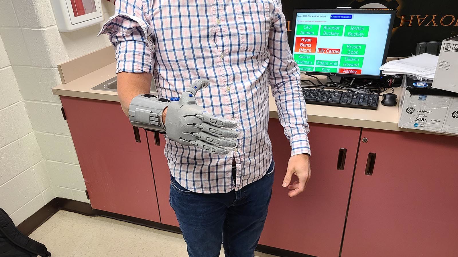 A client tries on his custom prosthetic hand designed by the Sequoyah High School Robotics Team.