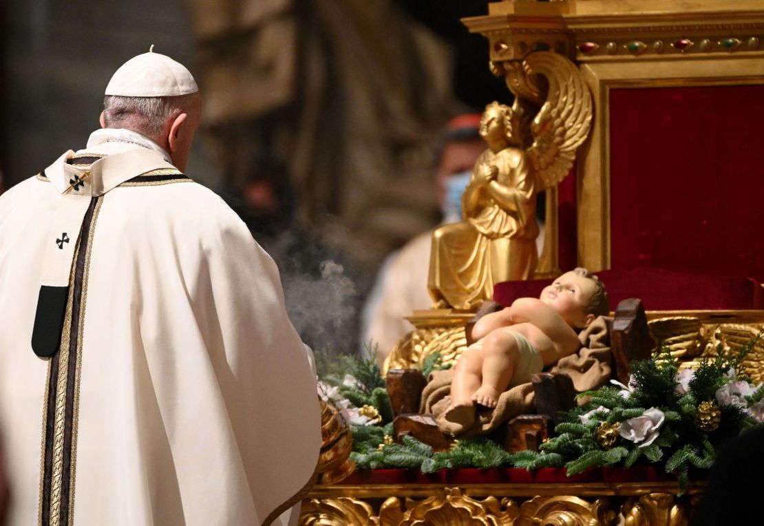 Francis prepares to kiss a figurine of baby Jesus during a Christmas Eve mass at St. Peter's basilica in the Vatican.