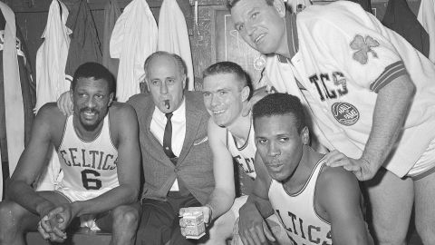 In this April 9, 1964, file photo, Boston Celtics, from left, Bill Russell, coach Red Auerbach, Tommy Heinsohn, Jim Locustoff, and K.C. Jones celebrate in the locker room after clinching their eighth straight Eastern Division playoff title at the Boston Garden in Boston. 
