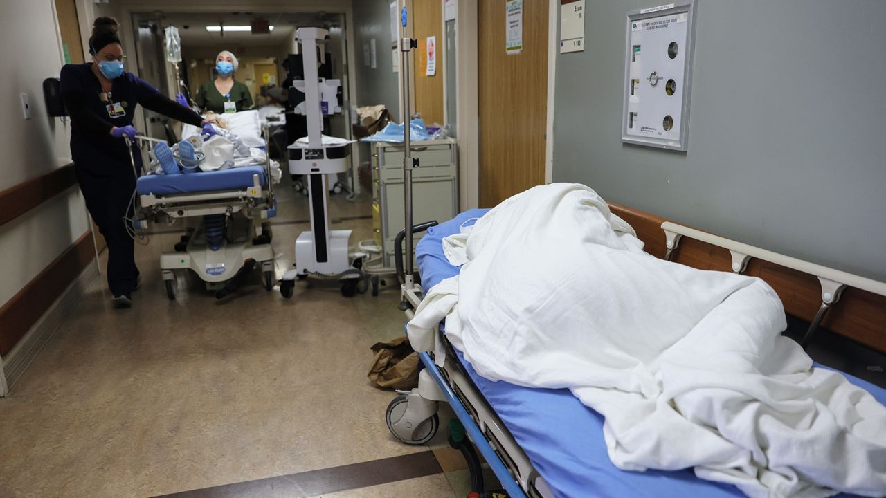 A patient lies on a stretcher in the hallway of the overloaded emergency room at Providence St. Mary Medical Center in Apple Valley, California, on December 23, 2020.