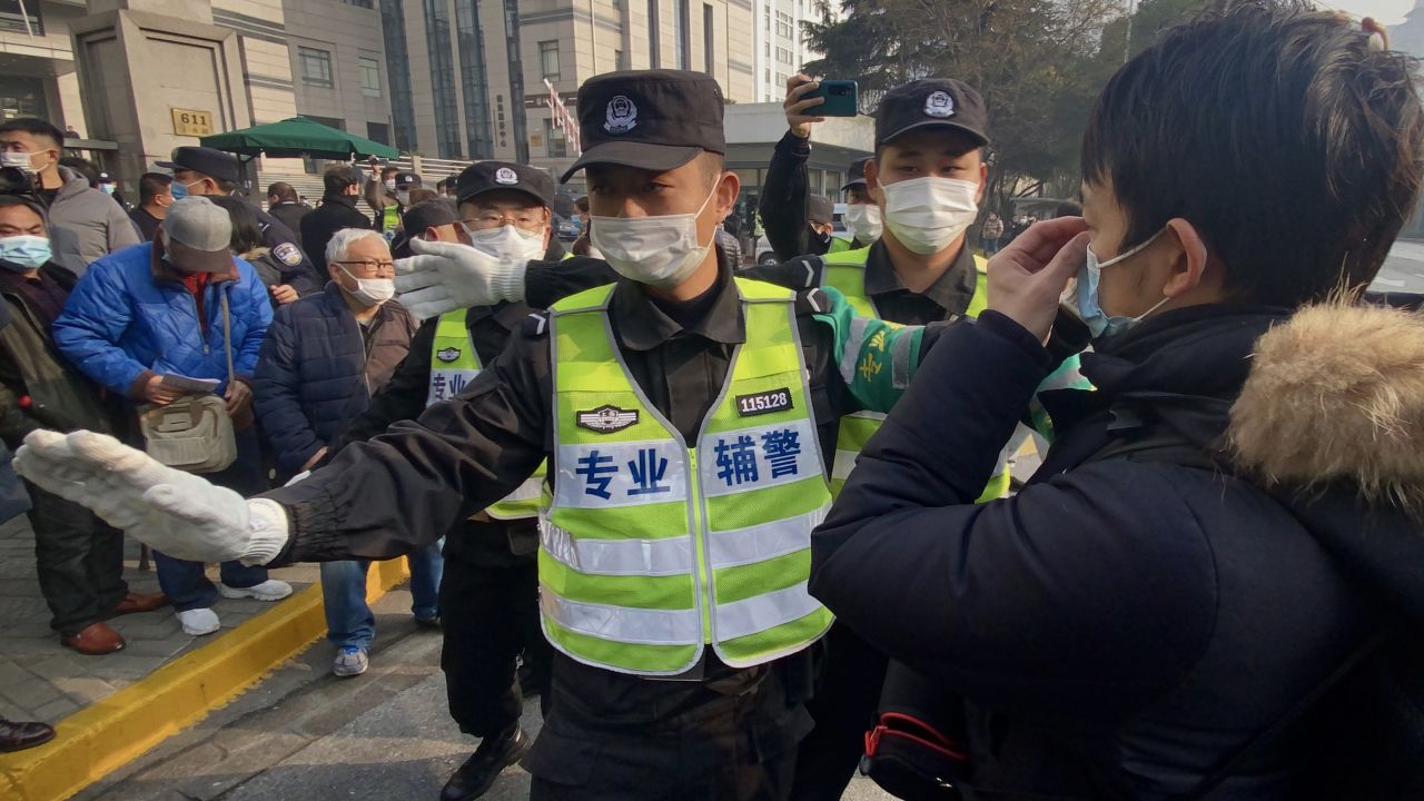 Police attempt to stop journalists from recording footage outside the Shanghai Pudong New District People's Court, where Chinese citizen journalist Zhang Zhan - who reported on Wuhan's Covid-19 outbreak and placed under detention since May - is set for trial in Shanghai on December 28, 2020. (Photo by Leo RAMIREZ / AFP) (Photo by LEO RAMIREZ/AFP via Getty Images)