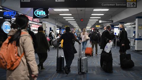 Passengers walk through a crowded terminal at Dulles International Airport in Virginia on Sunday. Holiday travel and indoor gatherings spread the coronavirus.