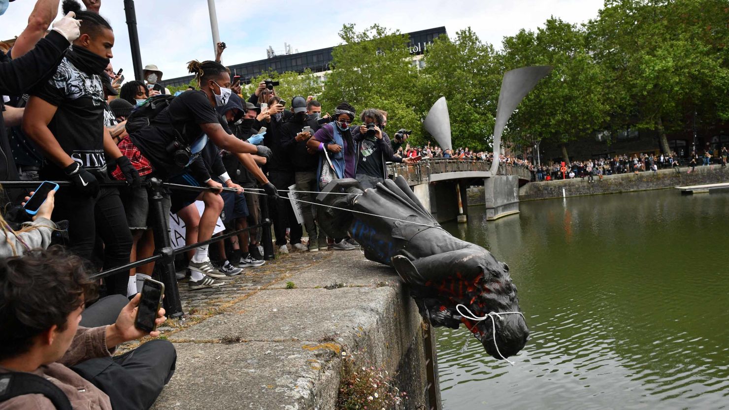 Protesters throw a statue of slave-trader Edward Colston into Bristol harbor during a Black Lives Matter protest in June.