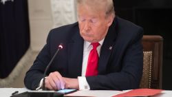 US President Donald Trump uses his cellphone as he holds a roundtable discussion with Governors about the economic reopening of closures due to COVID-19, known as coronavirus, in the State Dining Room of the White House in Washington, DC, June 18, 2020. (Photo by SAUL LOEB / AFP) (Photo by SAUL LOEB/AFP via Getty Images)