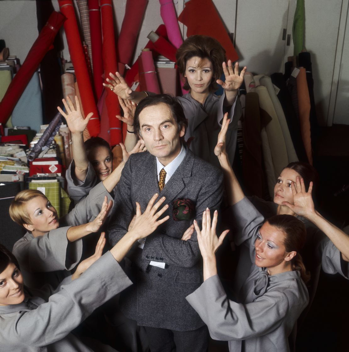 Pierre Cardin stands in his studio surrounded by models.