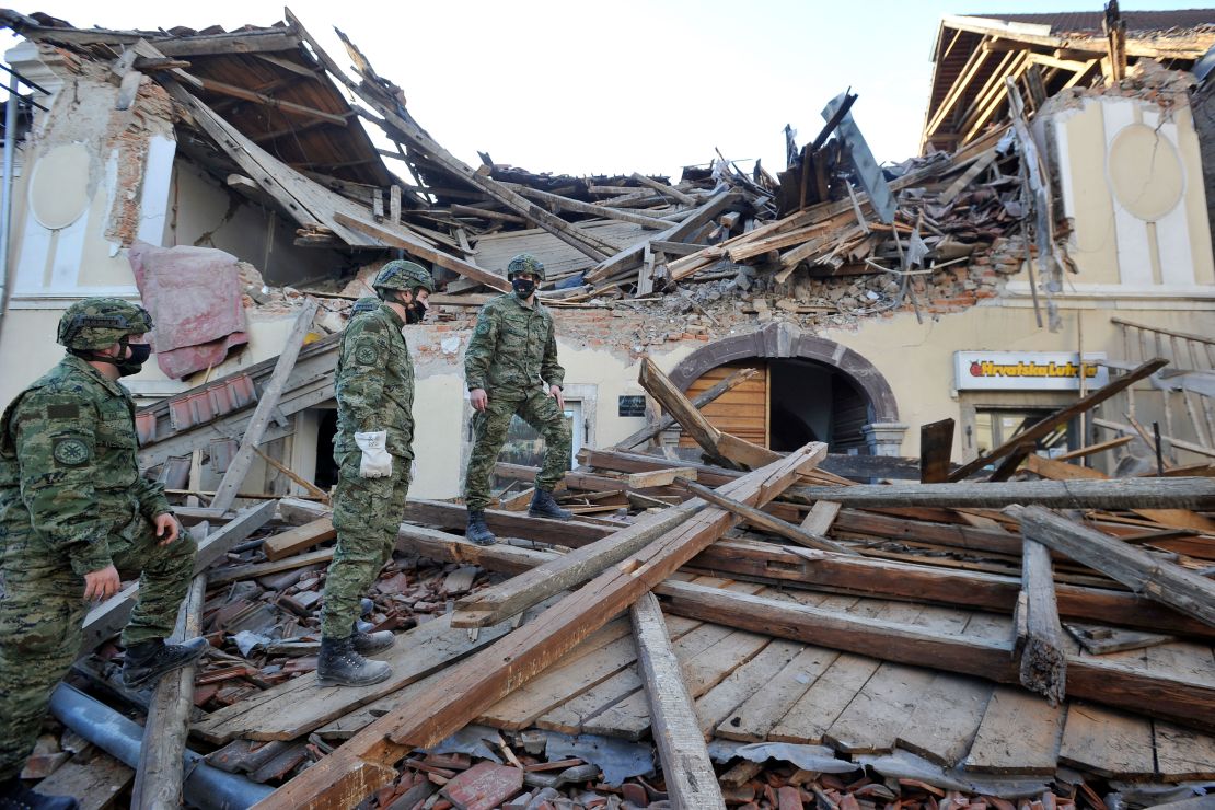 Soldiers inspect the destruction in Petrinja.