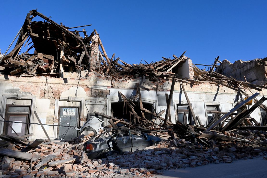 The wreckage of a car and buildings in Petrinja.