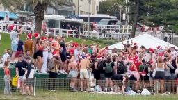 People wearing Santa hats gather at Bronte Beach, amid the coronavirus disease (COVID-19) outbreak, in Sydney, Australia December 25, 2020 in this still image taken from social media video. INSTAGRAM/@stucrabb/via REUTERS THIS IMAGE HAS BEEN SUPPLIED BY A THIRD PARTY. MANDATORY CREDIT. NO RESALES. NO ARCHIVES.