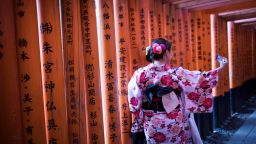 In this picture taken on December 9, 2018 tourists wearing kimono take selfies on the walking pass through the torii gates at Fushimi Inari Shrine in Kyoto. (Photo by Behrouz MEHRI / AFP)        (Photo credit should read BEHROUZ MEHRI/AFP via Getty Images)