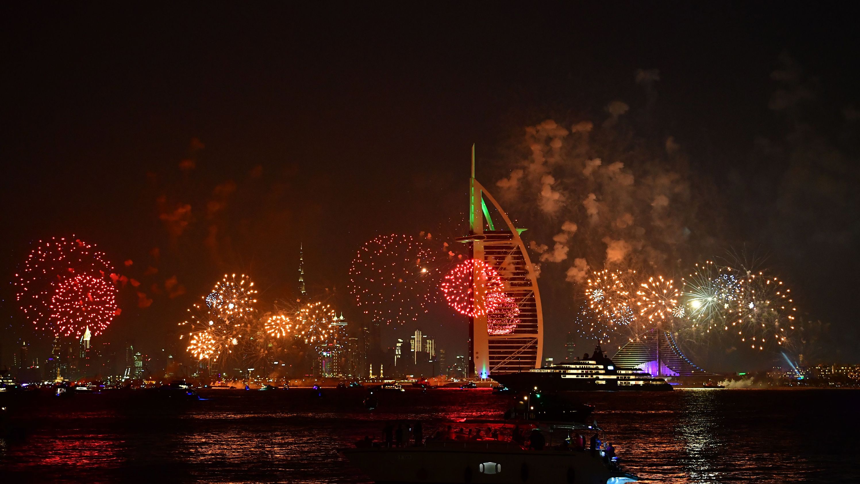 New Year's fireworks celebrations are seen above the Dubai skyline with the Burj Al Arab (R) and Burj Khalifa (L), the world's tallest building, on December 31, 2019. 