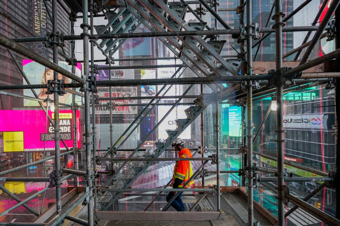 A construction worker walks down a staircase in the scaffolding of TSX Broadway under construction, Thursday, Oct. 29, 2020, in New York's, Times Square.