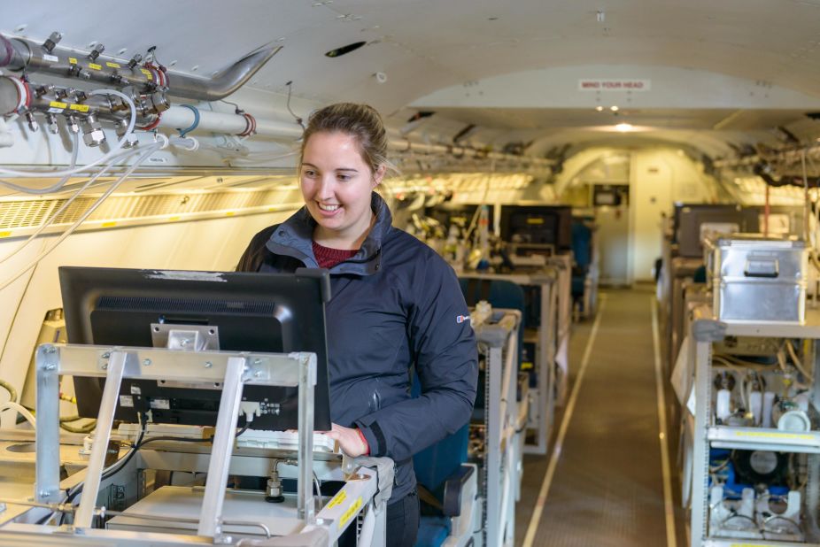 During research flights, the aircraft can carry up to 18 scientists. Rebecca Carling works surrounded by instrument racks that store specialized scientific equipment.