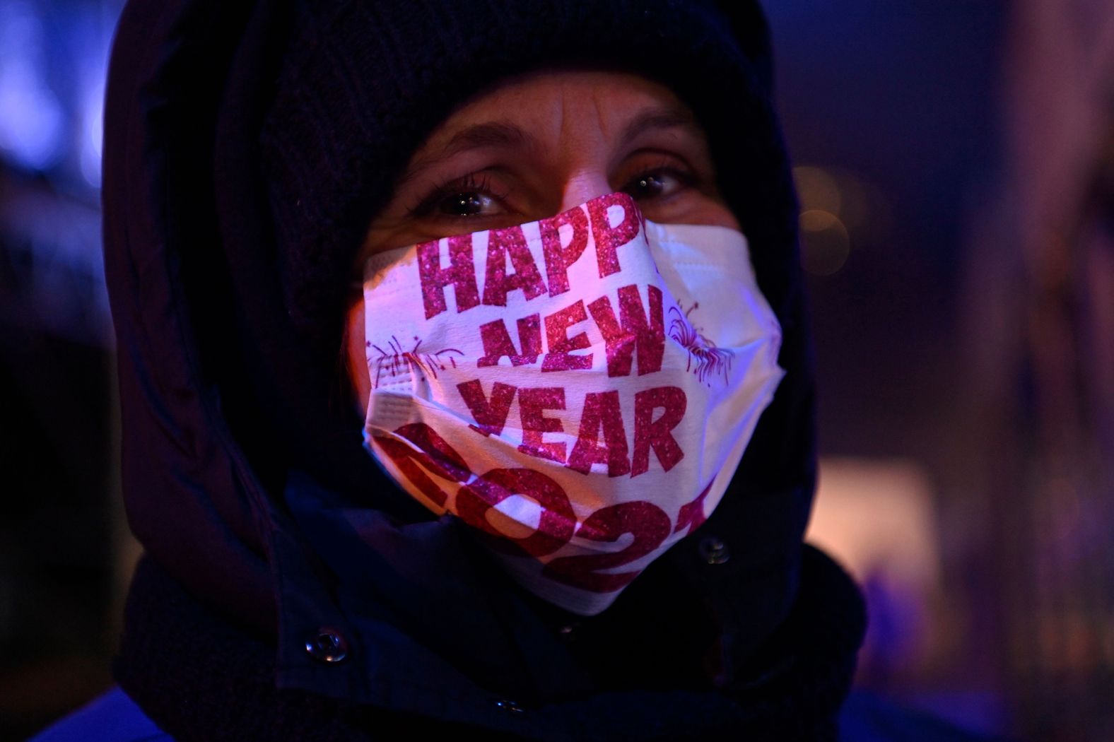 A member of the security staff at a concert in Berlin wears a face mask that reads "Happy New Year 2021."