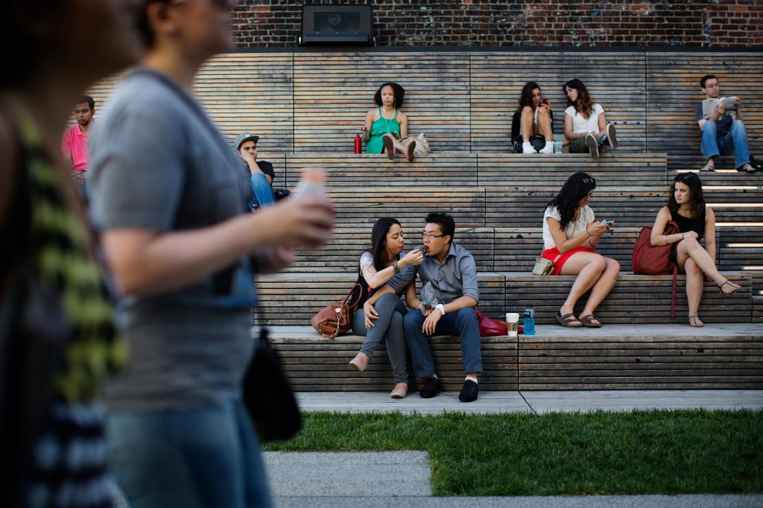 Pedestrians sit in a viewing area of New York's High Line park in 2013.