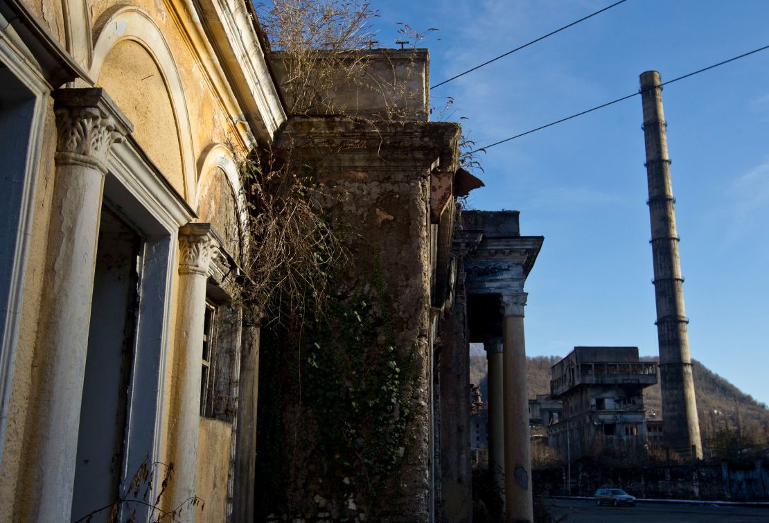 The car drives next to the abandoned power plant in the city of Tkvarcheli, in Abkhazia, Russian interruption of the Georgian region, 26. December 2013 years.