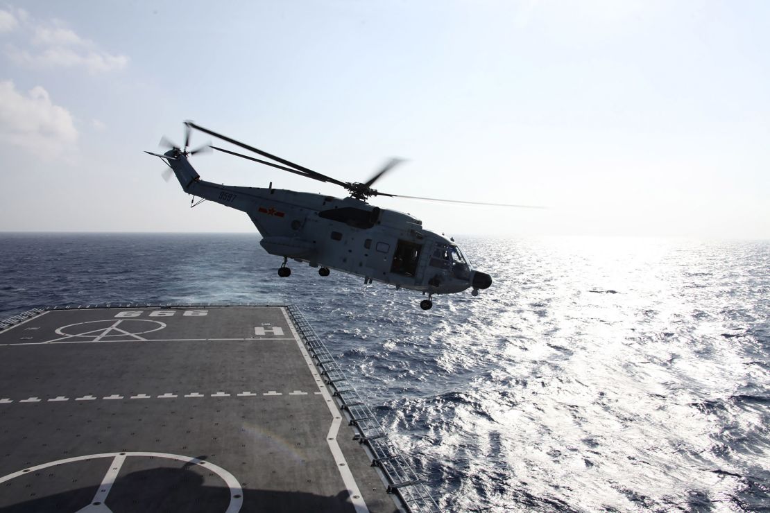 A helicopter takes off from Chinese warship Jinggangshan during an early search for the missing Beijing-bound Malaysia Airlines flight 370 on March 11, 2014.