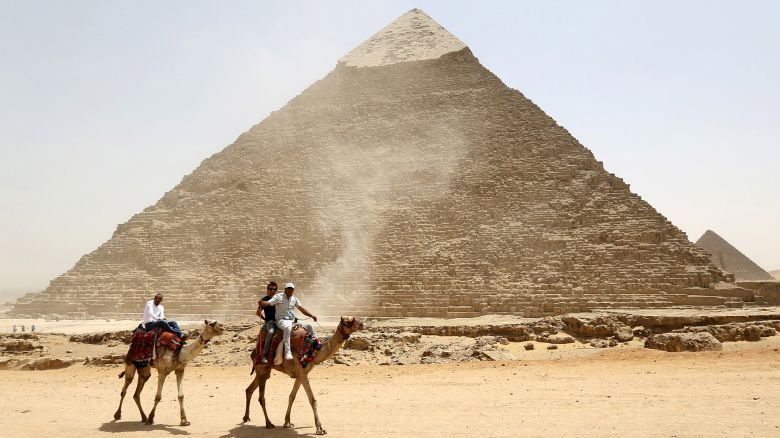 Tourists ride on camels next to the Pyramid of Khufu on the Great Pyramids of Giza, on the outskirts of Cairo, April 27, 2015. Local media reported Egypt's Minister of Antiquities Mamdouh al-Damaty attended the opening of two tombs that were under rennovation on Monday. One tomb belongs to the Priest of King Khufu while the other belongs to his eldest son. REUTERS/Mohamed Abd El Ghany