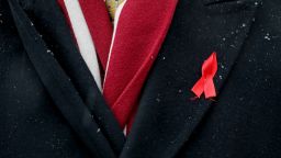 A participant with a red ribbon symbolising the fight against the HIV virus takes part in a ceremony to mark World AIDS Day near a monument in memory of AIDS victims in Kiev, Ukraine December 1, 2016.  REUTERS/Gleb Garanich