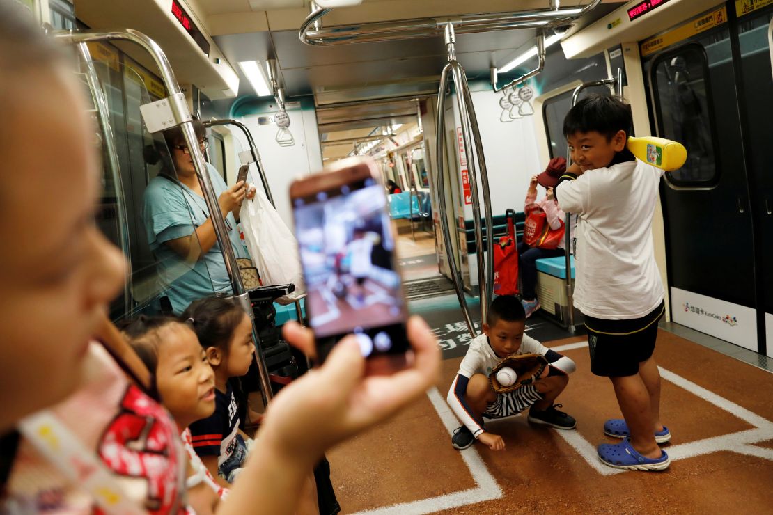 Children pose on a sports-themed Metro train in Taipei, marking the citys status as host of the 2017 Summer Universiade, an international sports event for university athletes.