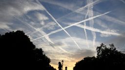 A runner is seen with aircraft contrails in the sky behind at dawn in London Britain September 21, 2017. REUTERS/Toby Melville