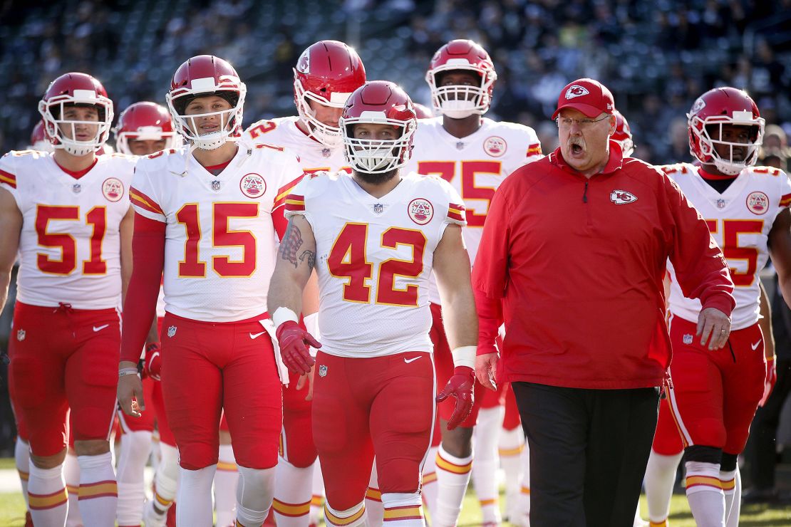 L'entraîneur-chef des chefs Andy Reid dirige les Chiefs 2018 sur le terrain avant le début d'un match contre les Raiders.