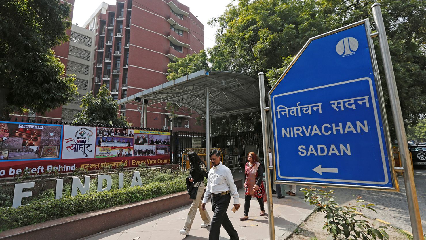Pedestrians walk past the Election Commission of India offices in New Delhi on March 11, 2019.