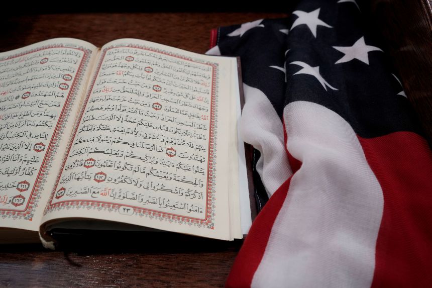 A Quran and and an American flag are seen on a podium at Dar Al-Hijrah Islamic Center in Falls Church, Virginia, in March 2019, before the start of a vigil for victims of an attack on a mosque in New Zealand.
