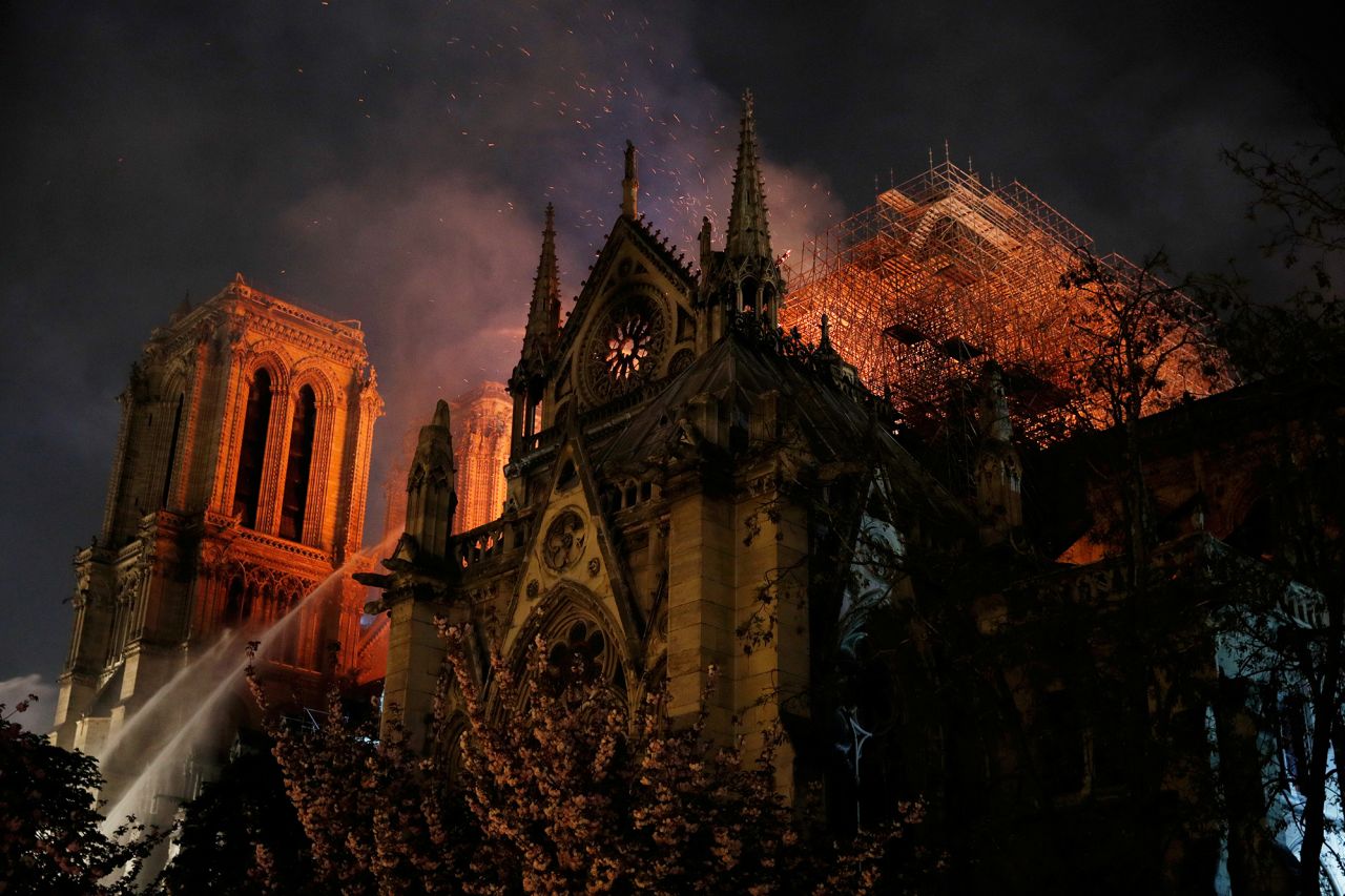 Sparks fill the air as Paris firefighters battle to extinguish flames.