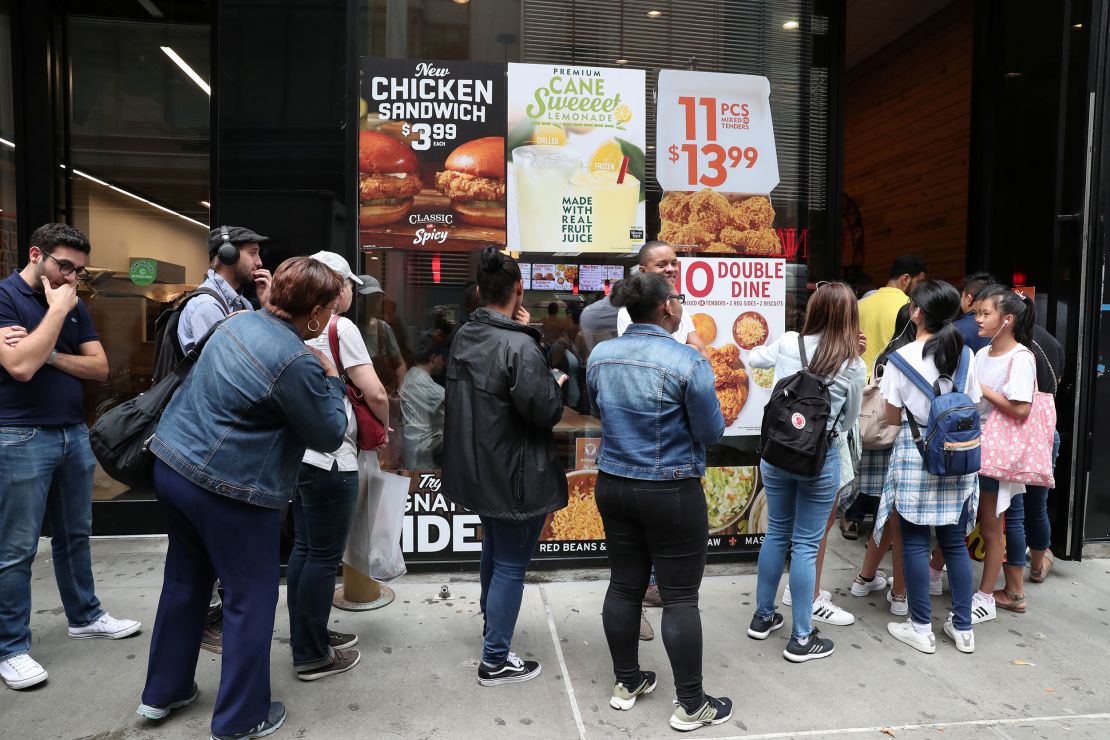 People wait in line outside a Popeyes Louisiana Kitchen in New York City in 2019.
