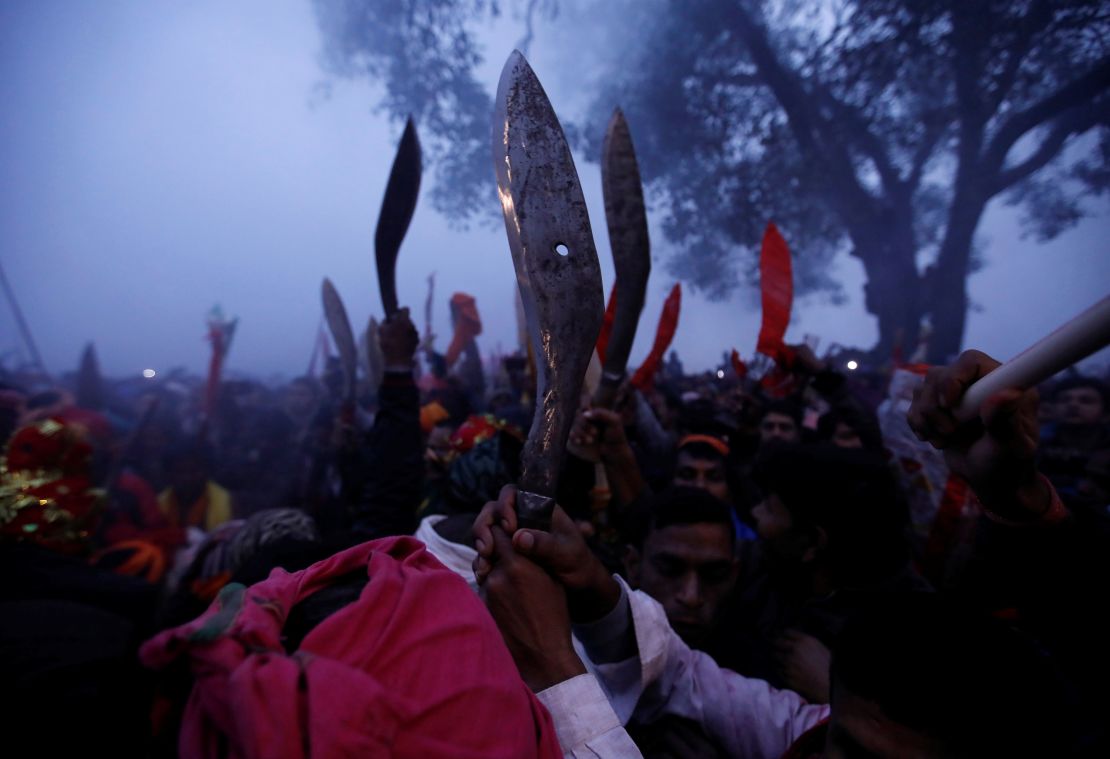 Devotees raise their sacrificial blades as the sacrificial ceremony of the "Gadhimai Mela" festival begins at Bariyarpur in Nepal on December 3, 2019.