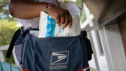 A United States Postal Service (USPS) employee delivers an Amazon Prime package in Houston, Texas, U.S., August 18, 2020.