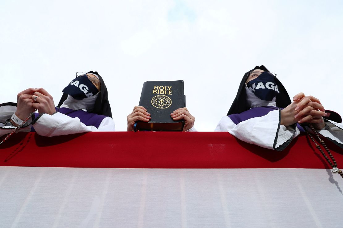 Supporters hold the Holy Bible as President Donald Trump speaks during a campaign event at the Pickaway Agriculture and Event Center in Circleville, Ohio, on October 24, 2020.