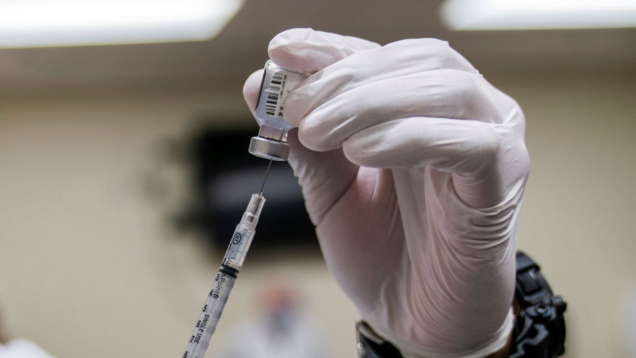 A medical professional reconstitutes a dose of COVID-19 vaccine at the Walter Reed National Military Medical Center in Bethesda, Maryland, on December 14, 2020.